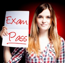 Student holding up paper which says `Exam Pass'