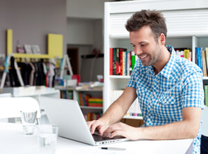 A male distance learning student studying from a laptop