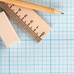 Maths equiptment on graph paper including a pencil, rubber and a ruler