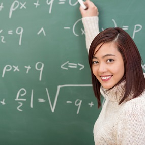 A level Maths and Mechanics Student writing on blackboard