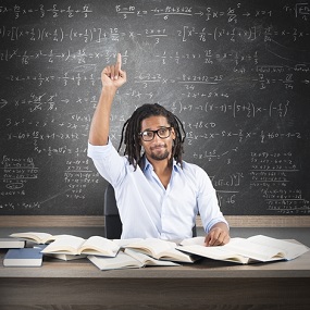 Student studying Mathematics A level in front of a board covered in formulas