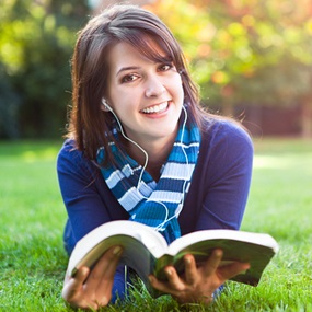 Student reading a Sociology GCSE Textbook in sunny field